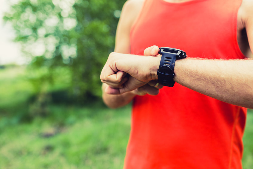 Man running and checking sport smart watch